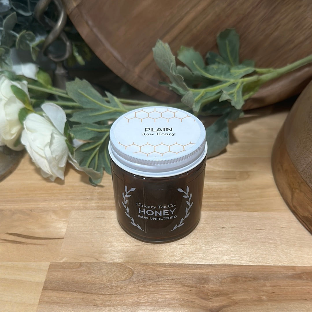 Chicory Tea Co.'s Ohio Honey front view on a wood floor with leaves and a barrel in the background